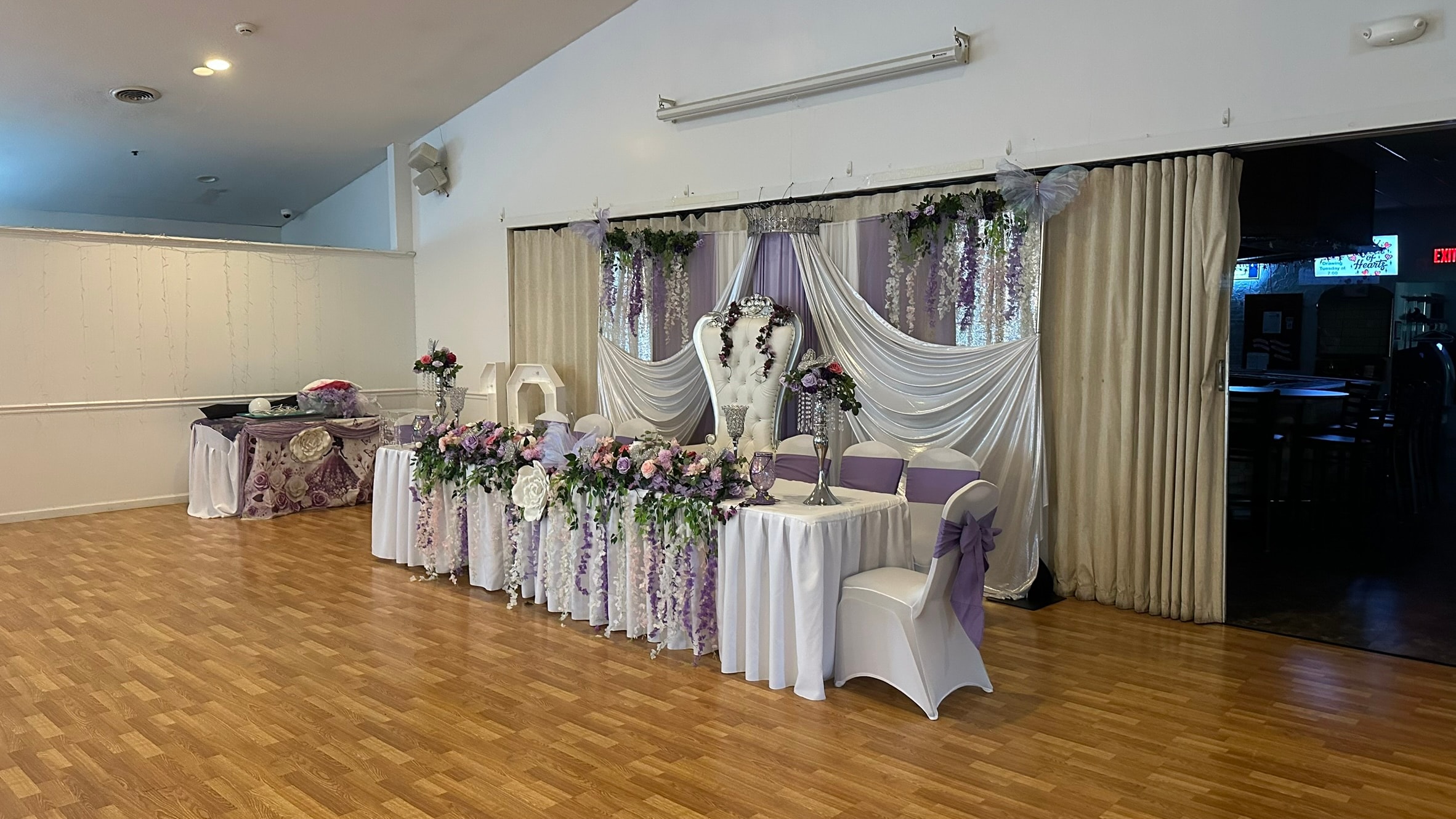 Watertown Elks Lodge banquet room decorated for a wedding with purple and white floral backdrop